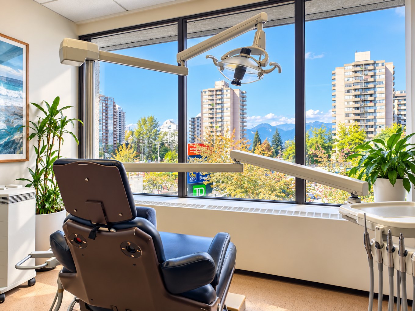 Bright treatment room at Atmos Dental with large windows overlooking Metrotown and the North Shore mountains