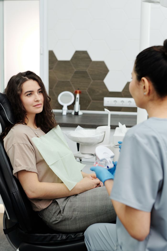 A dentist and patient in a modern clinic during a dental consultation.