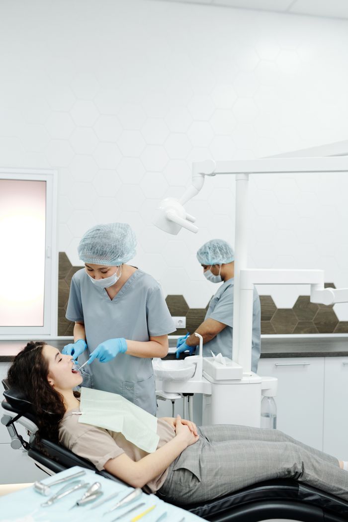 A dentist performs a dental procedure on a patient in a modern clinic setting, emphasizing healthcare.